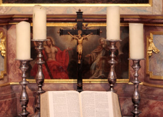 Altar in der Bibrakirche mit Kerzen, Kreuz und Bibel